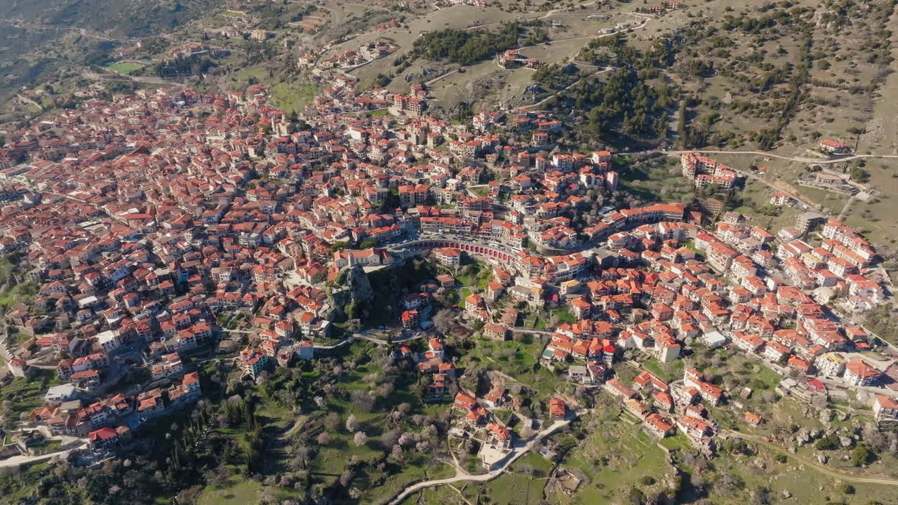 Ampia veduta aerea di Arachova, un villaggio compatto raggruppato lungo i pendii sotto il Monte Parnaso in una giornata limpida, orbita panoramica