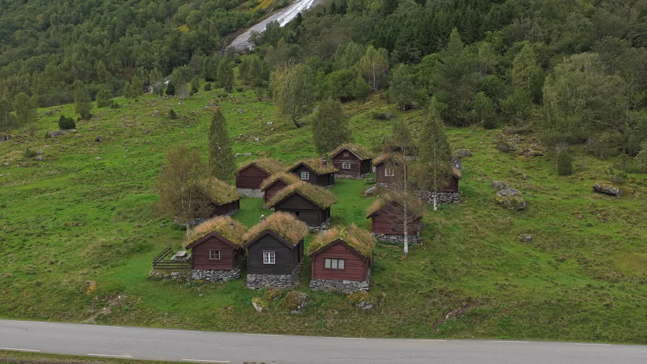 Letecký pohled na chaty u průzračného jezera a drsné štíty, Norsko