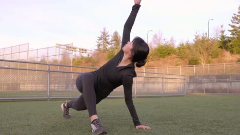 fitness woman performs twisting lunge transitioning to lizard pose