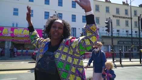 positive signing protestant mixed race colorful clothing and backround by the seaside in the middle of the road slow motion