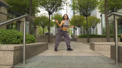 Influyente-Bailarina-Famosa-De-Instagram-Realizando-Sus-Movimientos-En-Un-Pequeño-Parque-Moderno-Al-Aire-Libre-Autobús-Rojo-De-Londres-Pasando-Detrás-De-Su-Cámara-Lenta