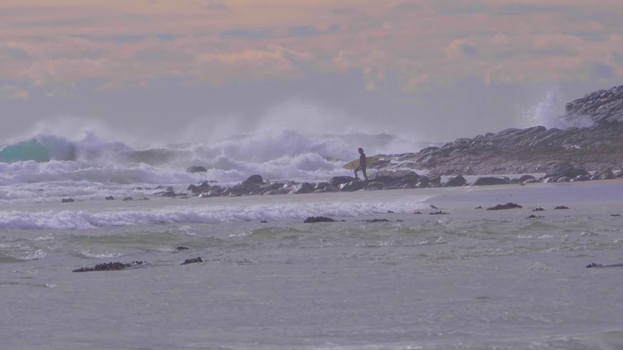 바다를 향해 걸어가는 서퍼 - 파도가 바위가 많은 해안에서 부서지고 튀는 - 크레센트 헤드, 시드니, 뉴 사우스 웨일즈, 호주에서 서핑