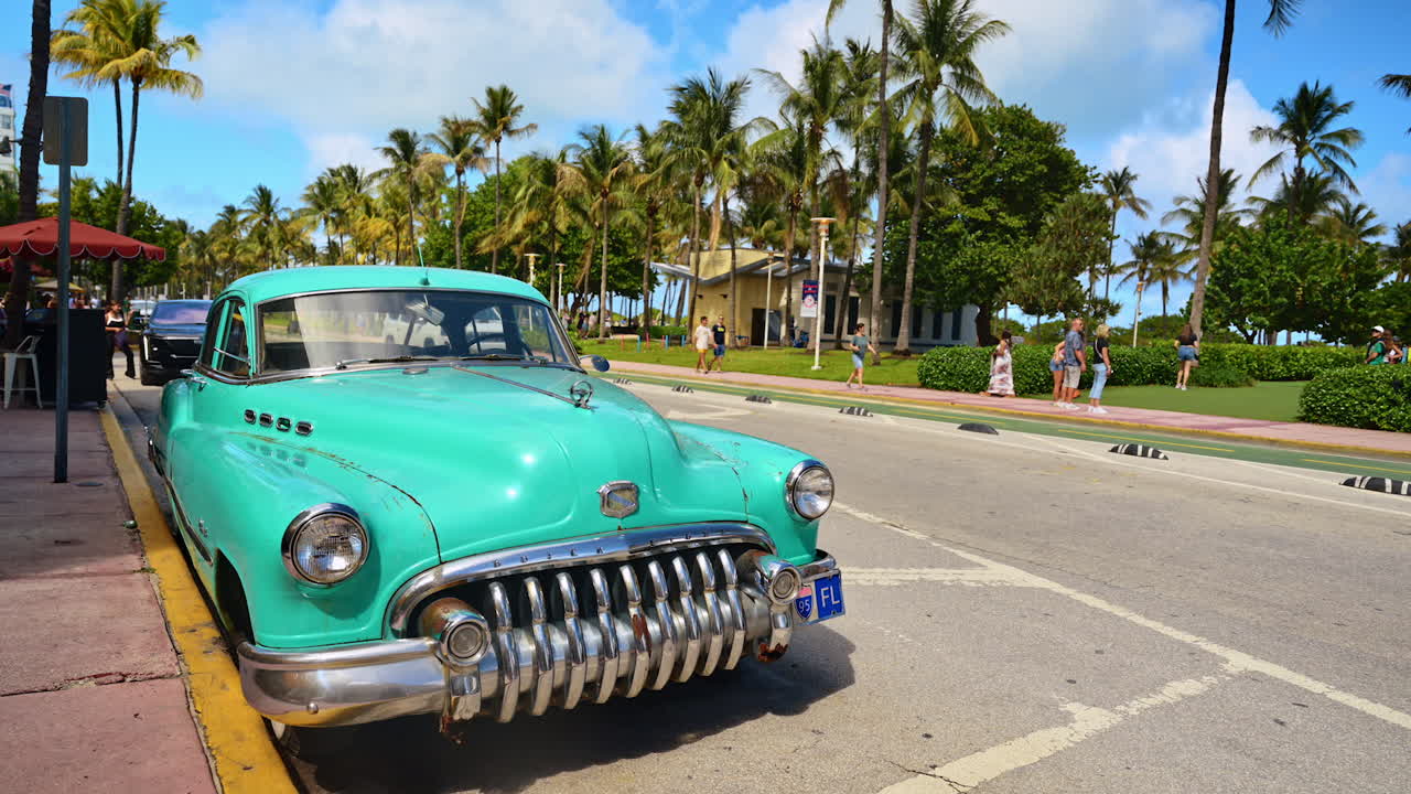 Miami, USA, 16 aprile 2026: Auto d'epoca turchese parcheggiata su Ocean Drive a Miami. Automobile classica retrò su una strada tropicale con palme e traffico moderno.