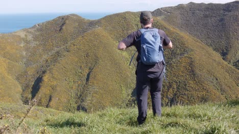 A-day-hiker-sitting-on-the-grass-to-take-a-rest-with-a-beautiful-view