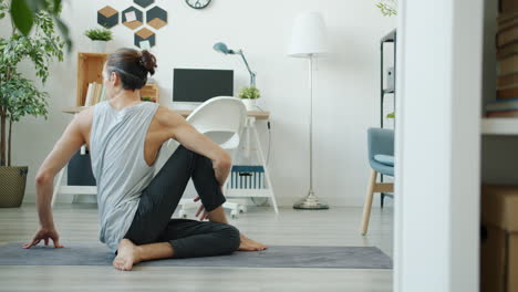 uomo che pratica yoga a casa