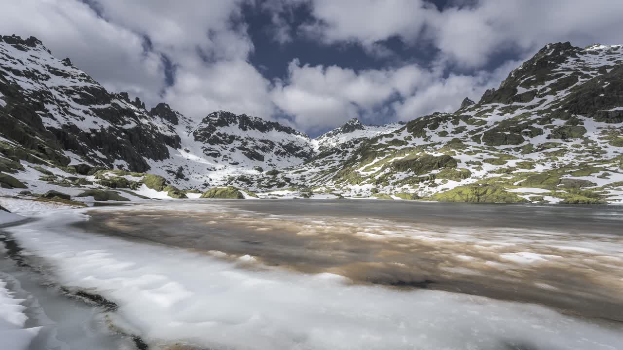 nubes que fluyen sobre el lago congelado con montañas nevadas