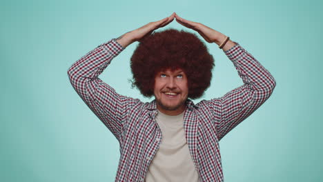 man playing childish catching up game, feeling in safe making roof above head with hands, insurance