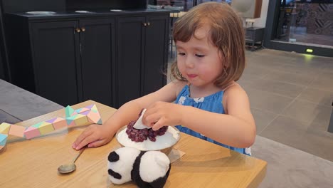 adorable little girl eating patbingsu - close up