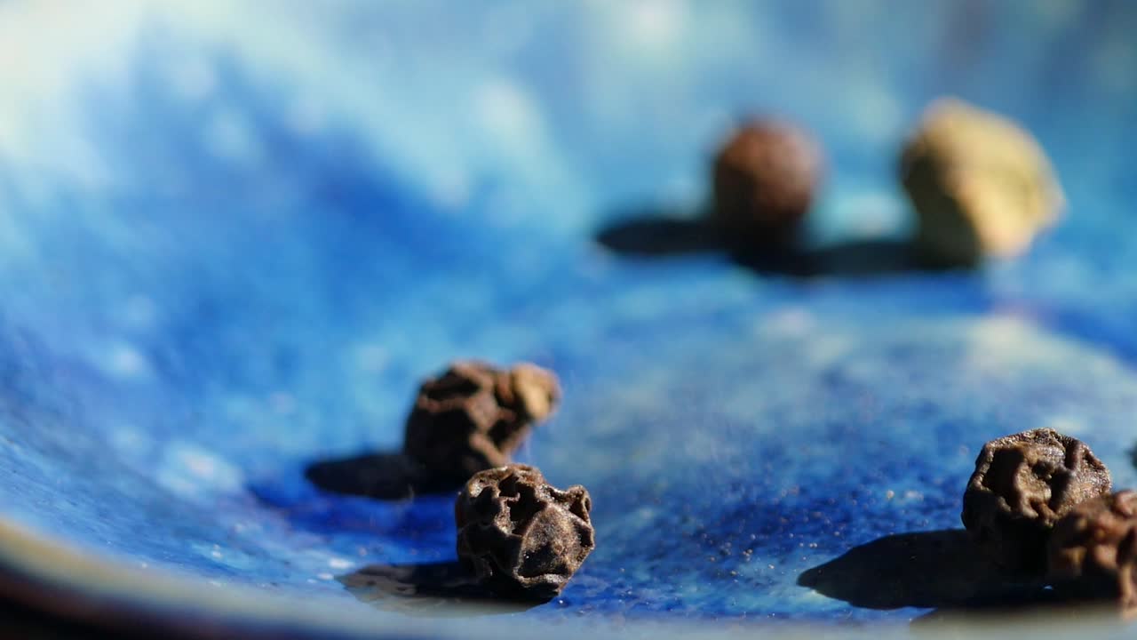 video de primer plano de especias enteras mezcladas de pimienta blanca, pimienta roja y pimienta negra.