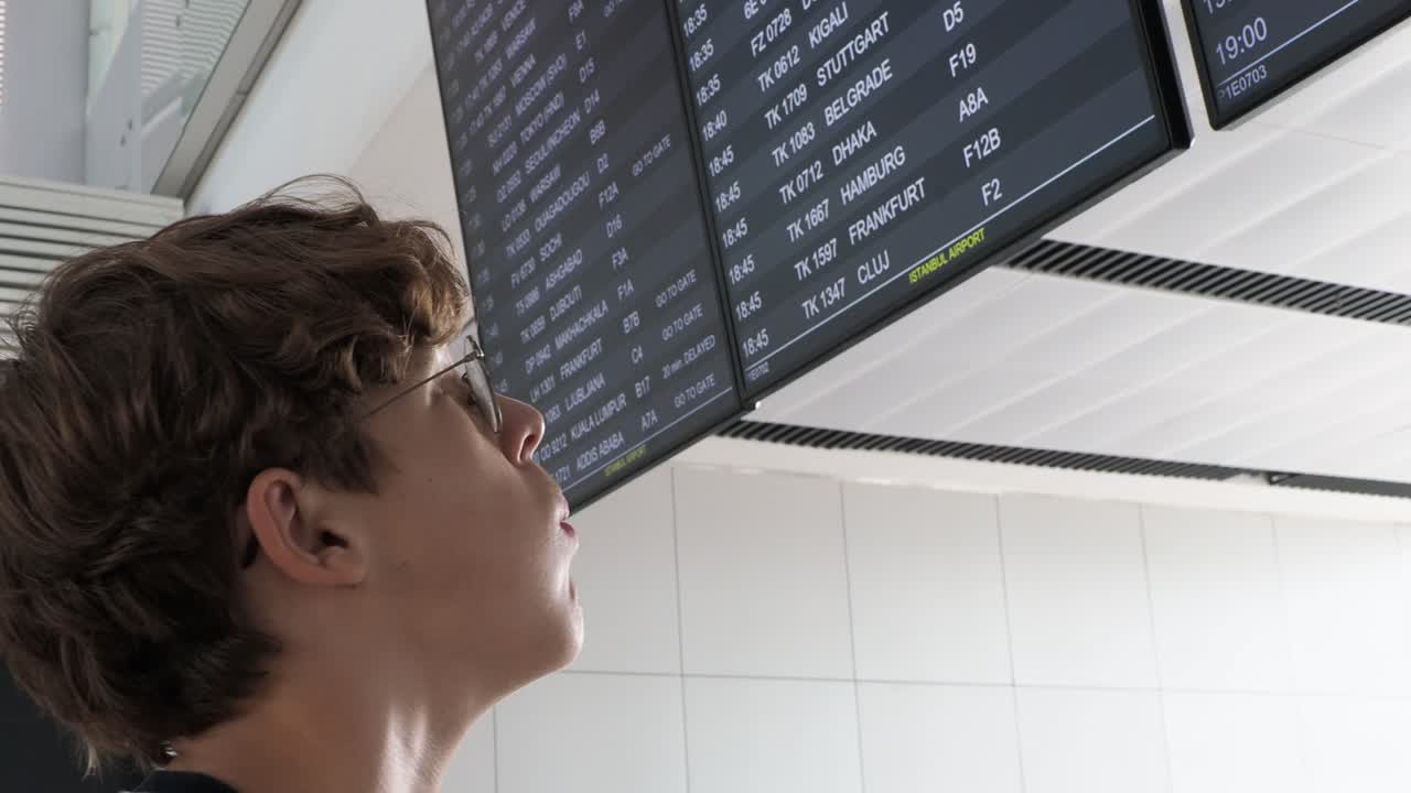 Man checking flight information board at airport