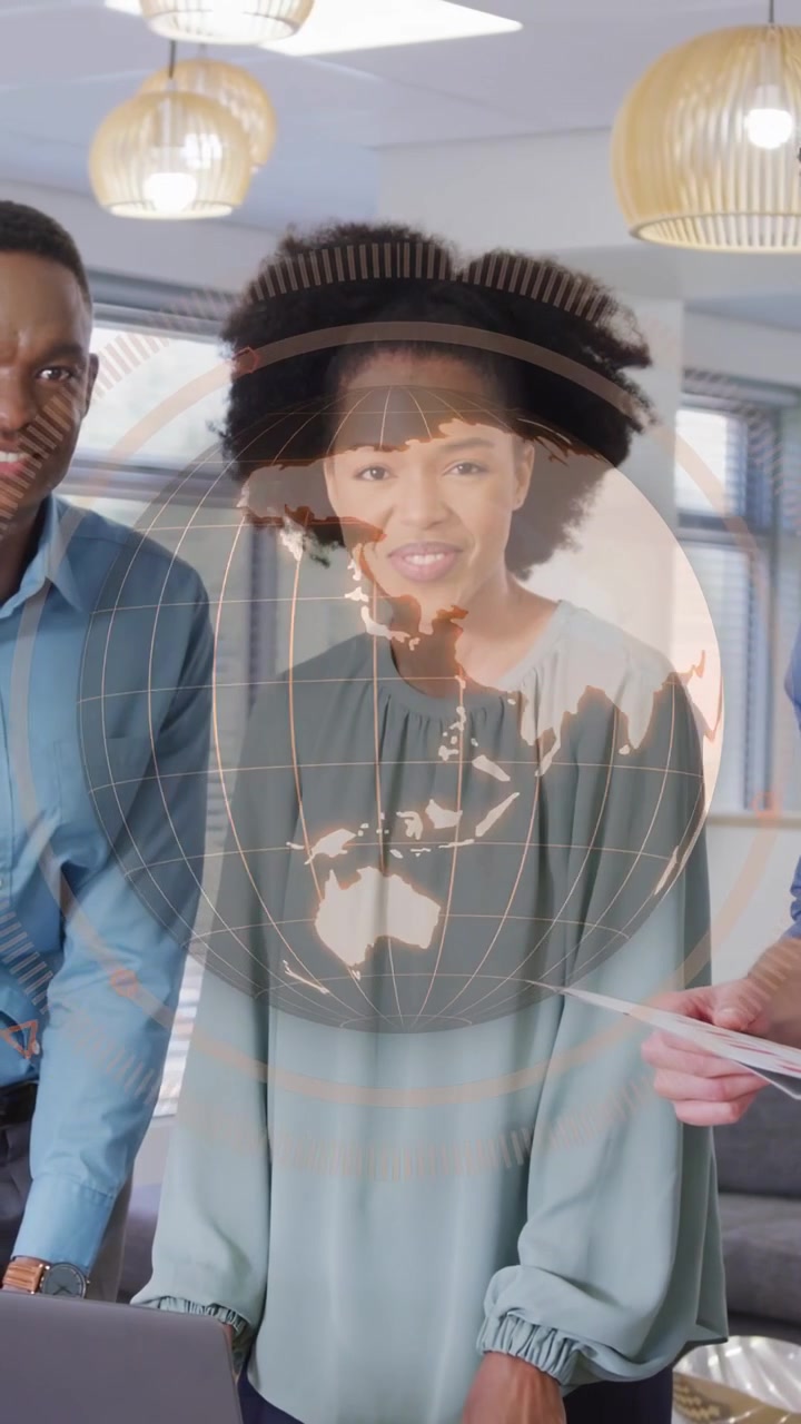 Vertical video: Team pitching biz, woman leaning on laptop, globe rotating over group, showing data