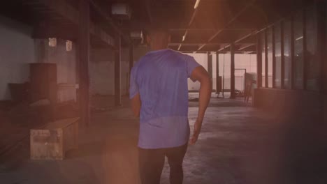 animation of colourful shapes over man jogging in an abandoned building
