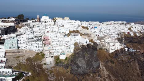 órbita-Aérea-De-La-Aldea-De-Imerovigli-En-El-Borde-Del-Acantilado-Y-Las-Iglesias-De-Panagia,-Santorini