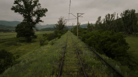 fly-over disused railroad covered with green meadows near atskuri, georgia