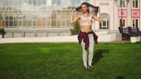 Junge-Hipster-Frau-Mit-Dreadlocks,-Die-An-Einem-Strahlend-Sonnigen-Sommertag-In-Einem-Park-Rad-Schlägt.-Zeitlupenaufnahme