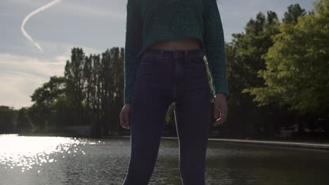 gorgeous italian fashion model posing in her outfit in front of a lake in london at golden hour