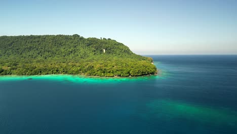 a drone flies toward a lush green island at port olry on the island of espiritu santo