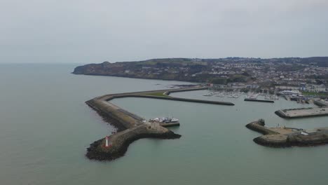 cinematic aerial orbit of howth harbour, focusing on the lighthouse