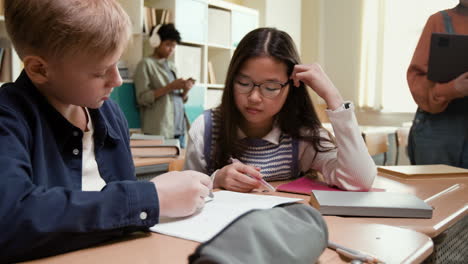 students working together at a desk in a classroom