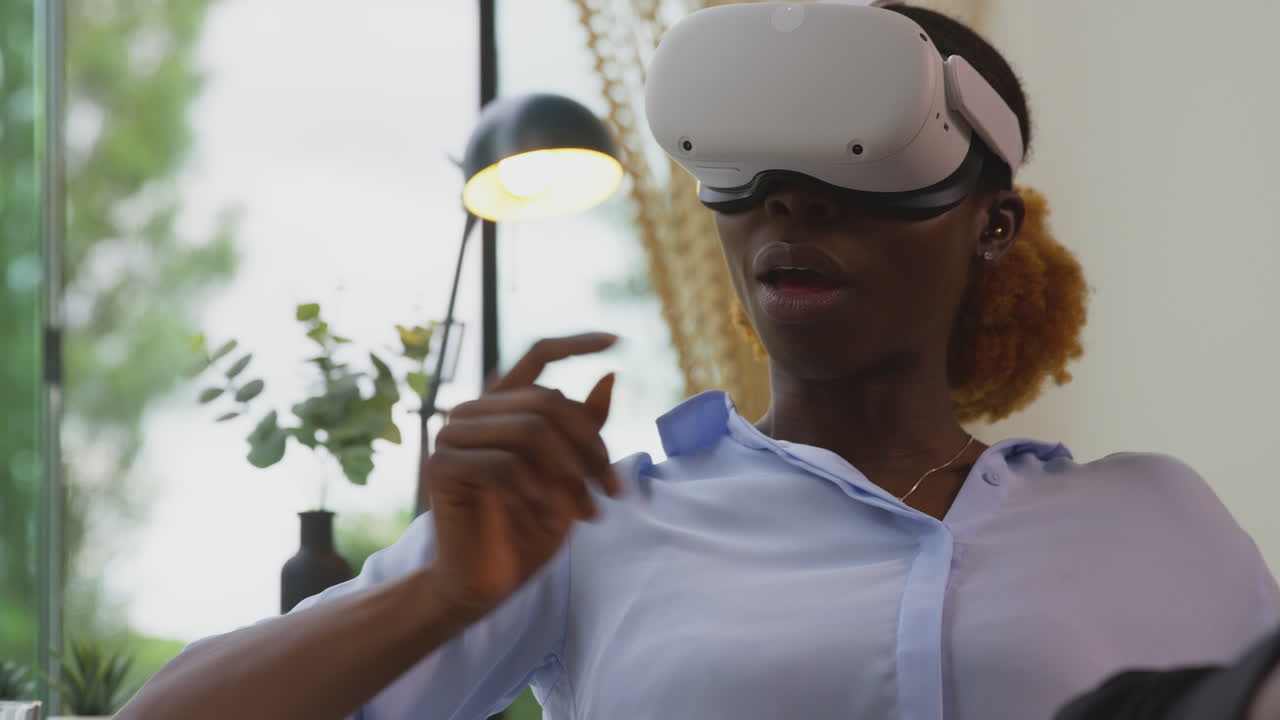 Donna che lavora dall'ufficio di casa con i piedi sulla scrivania, che indossa un visore VR con tecnologia AR