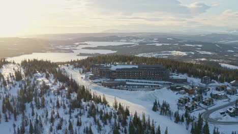 Vista-Aérea-De-Drones-Sobre-El-Albergue-De-Montaña-Copperhill-En-Åre,-Suecia-Durante-La-Puesta-De-Sol-Y-El-Invierno