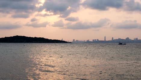 dramatic seascape sunset view with silhouette fishing boat from koh larn, pattaya, chon buri, thailand, uhd 4k video with copy space