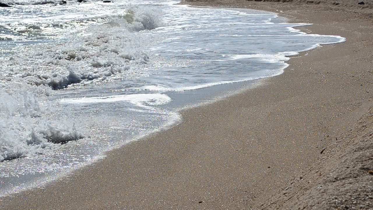 Spiaggia e onde, sole splendente. Riprese sulla spiaggia
