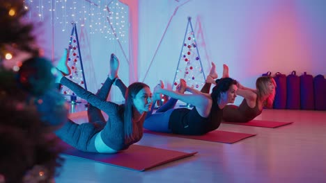 women practicing yoga poses during a christmas themed yoga session
