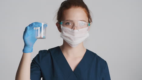 redheaded doctor in front of camera on gray background.