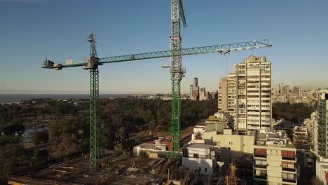 una grúa de construcción instalada en la parte superior de un edificio en construcción en medio de una zona urbana