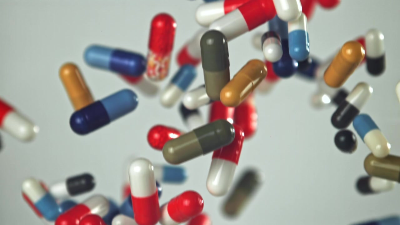 Pillole farmaceutiche colorate che cadono al rallentatore