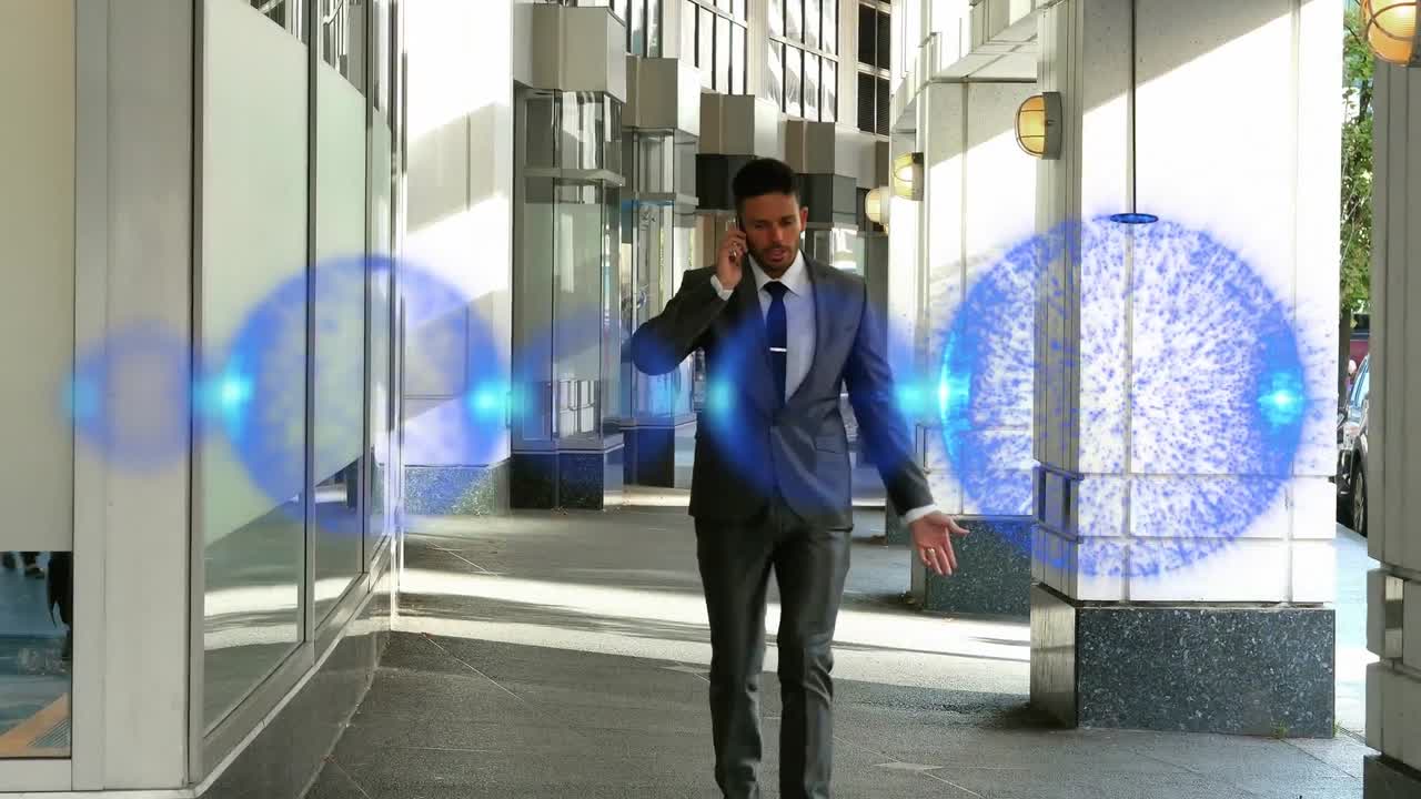 animación de manchas azules moviéndose sobre hombre de negocios caucásico hablando en teléfono inteligente en la oficina.