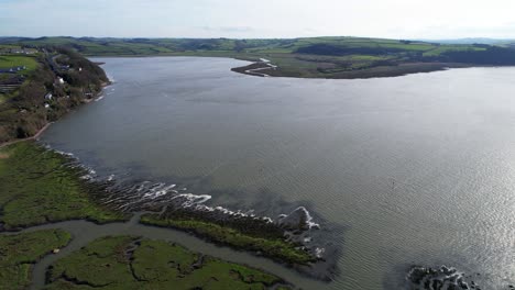 Aerial-view-of-Welsh-estuary-and-rolling-hills-in-a-quiet-morning,-4K