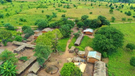 Drone-Volando-Sobre-Un-Pueblo-Con-Un-Auto-Conduciendo-Hacia-él