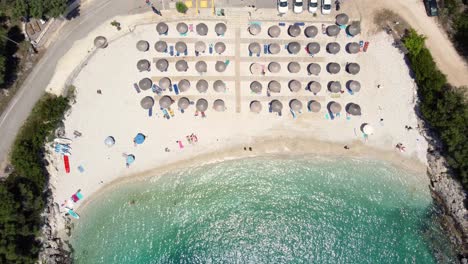 Draufsicht-über-Ammoussa-Strand,-Sonnenschirme-Muster,-Lefkada,-Griechenland