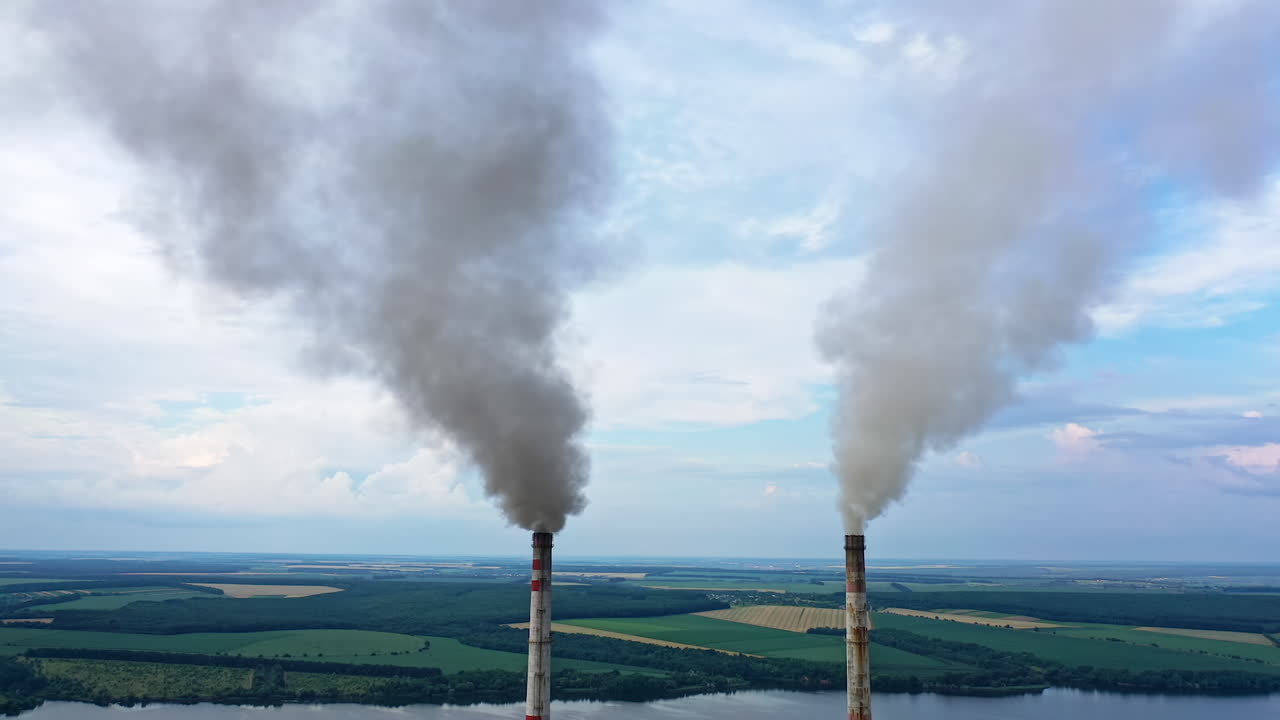 Atmospheric air pollution from industrial smoke. Pipes with chemical smoke from industrial plant. Thick smoke and steam pollute the environment. Climate change and global warming.