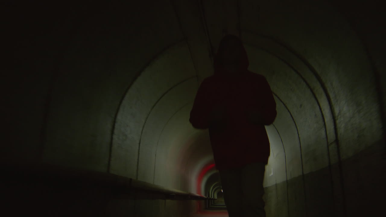 Young Guy Running through Tunnel with Red Light