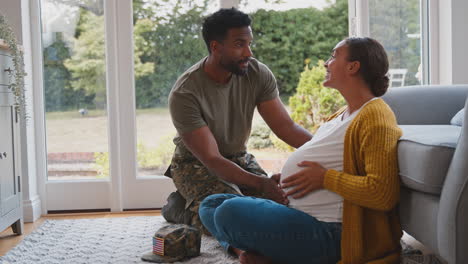 pareja con el ejército estadounidense marido en casa de licencia sorpresa esposa embarazada