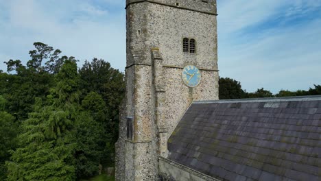 An-ascending-boom-shot-of-Holy-Cross-church-in-Goodnestone,-rising-from-the-entrance-to-the-top-of-the-church-tower