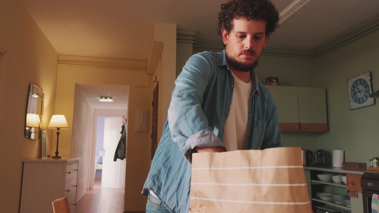 Man unpacking groceries in kitchen
