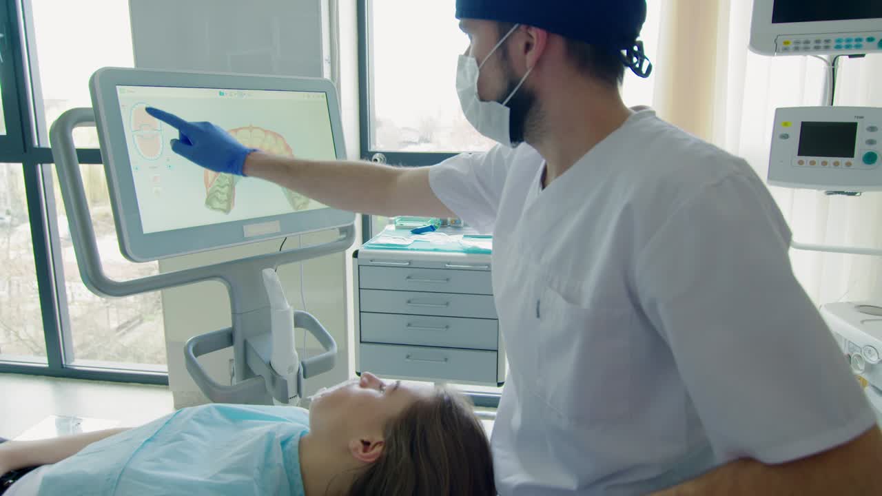 el dentista explica el escaneo 3d de los dientes de los pacientes