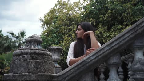 woman on ancient stone staircase in a garden