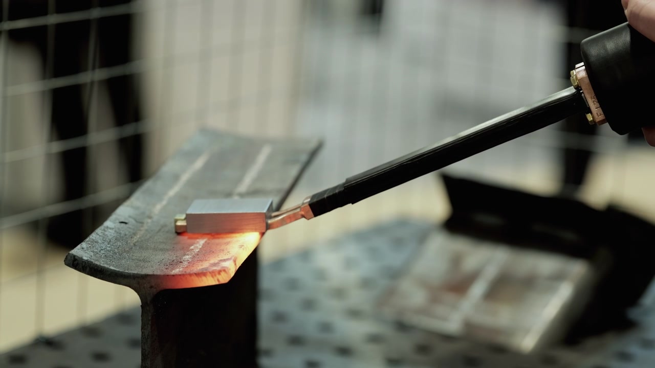 Industrial Worker Using Induction Heating Tool on Metal Beam