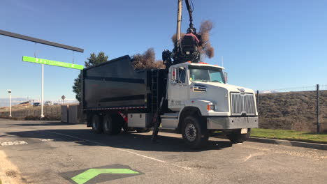 truck collecting tumble weeds with a big scoop next to highway 5 in grapevine, california