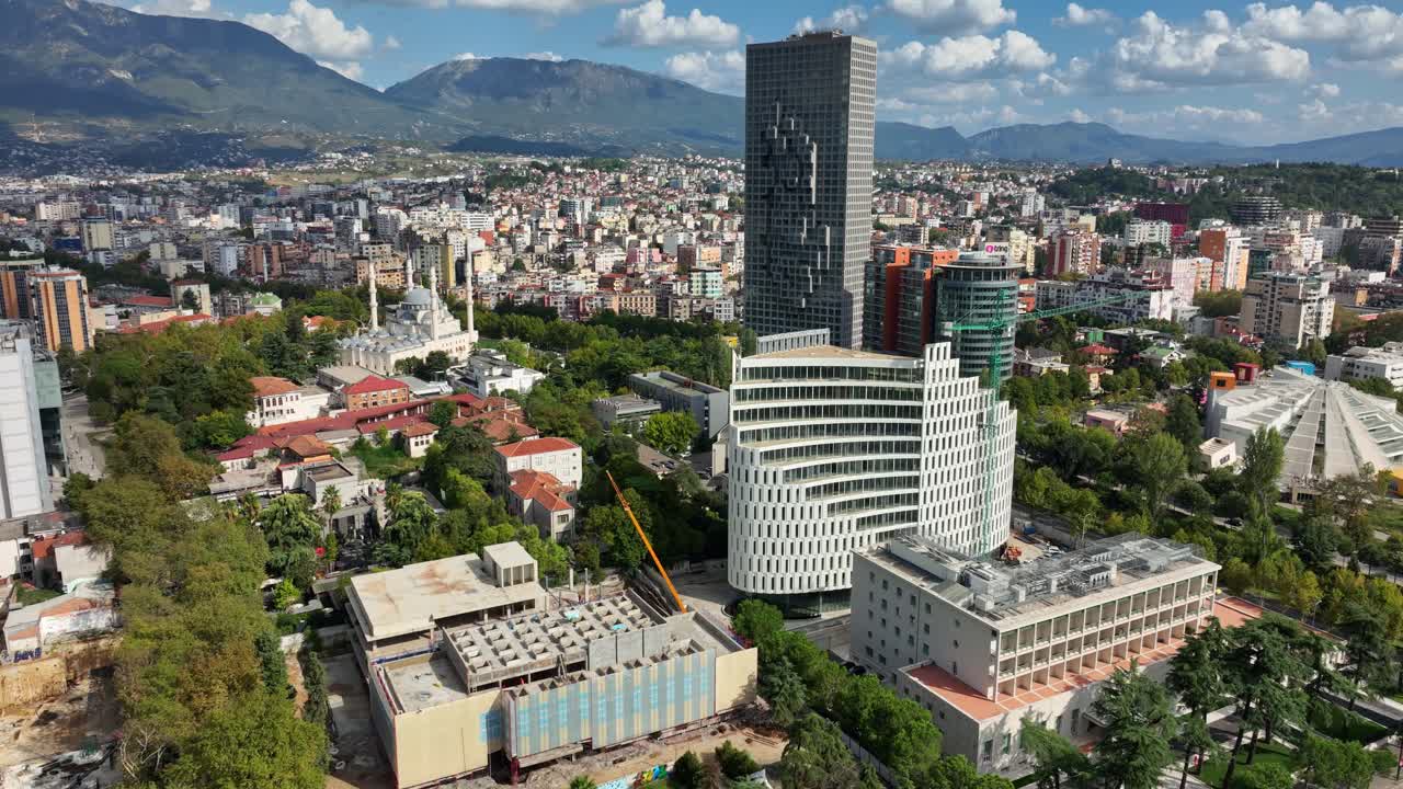 Tirana capital city townscape during the day with clouds and real estate in Albania - Orbit drone shot