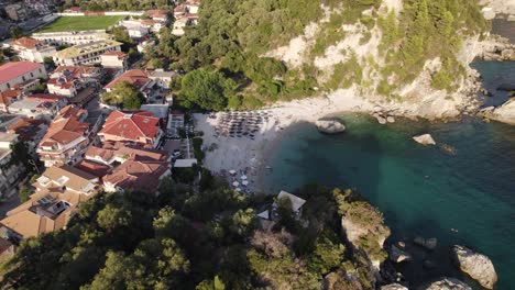 Vista-Orbital-De-La-Playa-De-Golfo-En-El-Pueblo-De-Parga,-Pequeña-Playa-De-Agua-Turquesa-Rodeada-De-Rocas,-Grecia