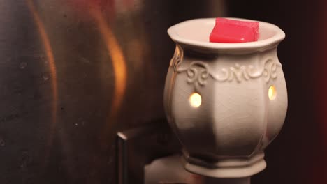 Red-Wax-Cube-Melting-On-A-Ceramic-Warmer---Closeup-Shot