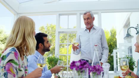 group of friends interacting with each other while having glasses of wine