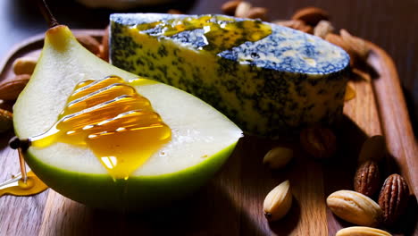 pear with honey, cheese, and nuts on a wooden board