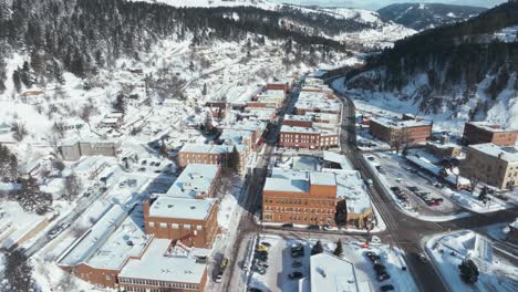 Flying-over-Main-Street-in-Deadwood,-South-Dakota-during-winter